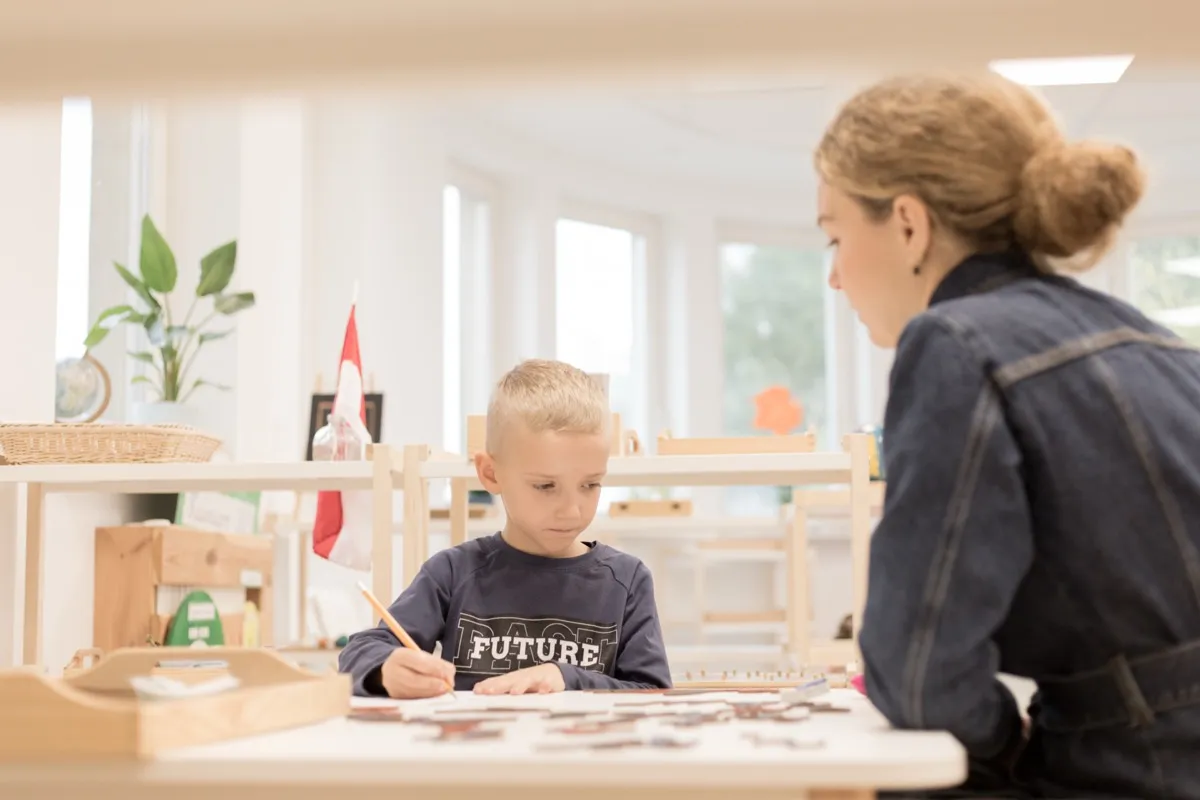 Chłopiec pracuje z nauczycielką w przedszkolu