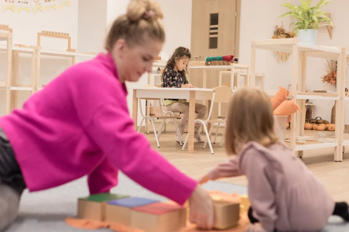 Nauczycielka z dziećmi podczas pracy z materiałami Montessori